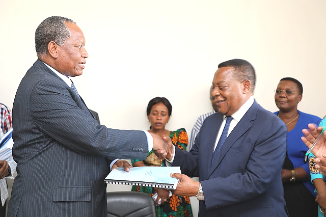 Waziri wa Mambo ya Nje na Ushirikiano wa Afrika Mashariki, Prof. Palamagamba Kabudi (kushoto) akimkabidhi Taarifa ya Makabidhiano ya Wizara ya Katiba na Sheria kwa Waziri wa Katiba na Sheria, Mhe. Dkt. Augustine Mahiga.
